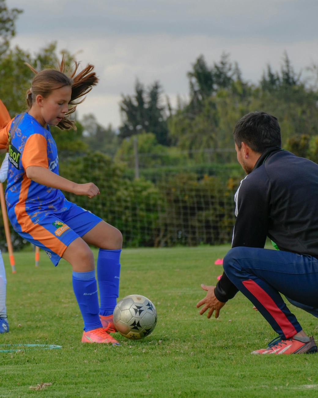 a girl and a coach at a Mill Hill Pro Touch Football training