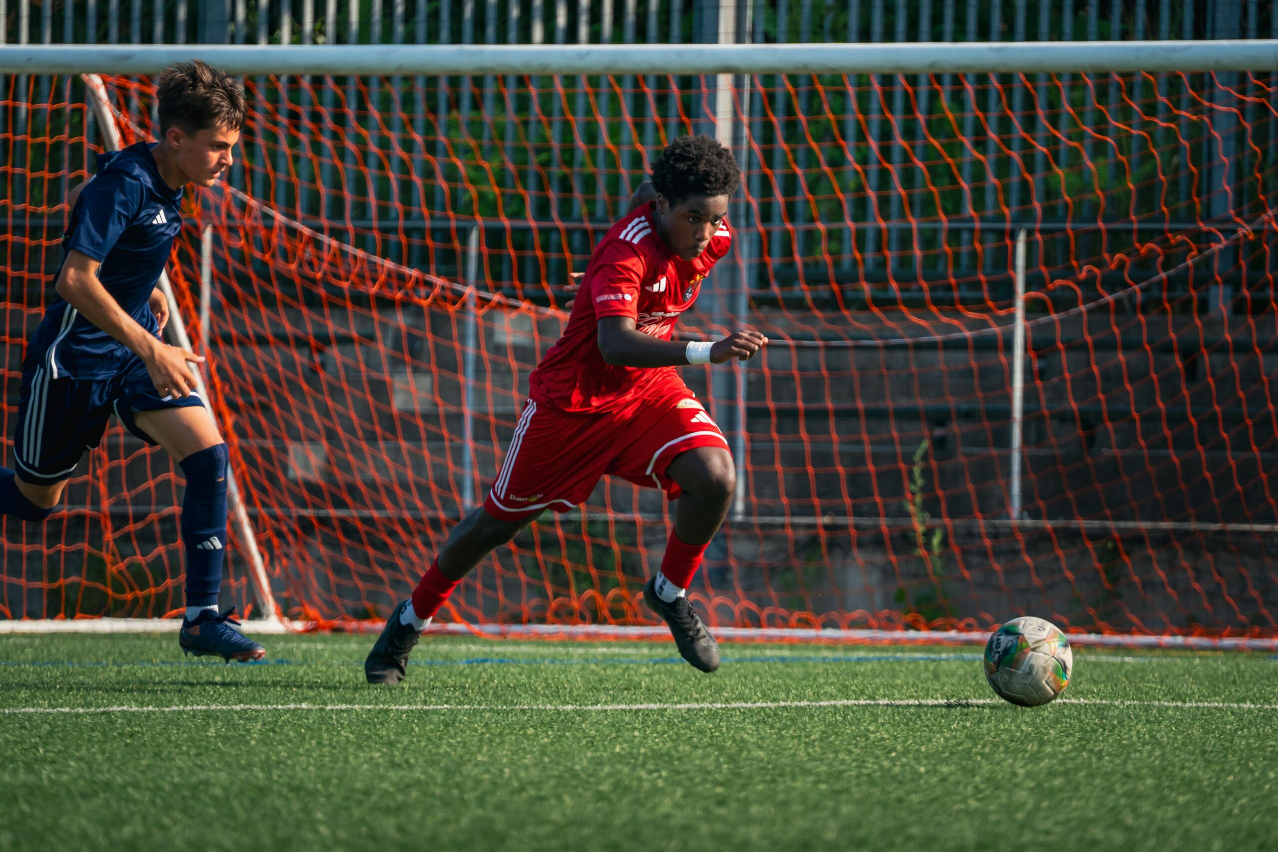 Football coach giving tactical instructions to young players on the pitch